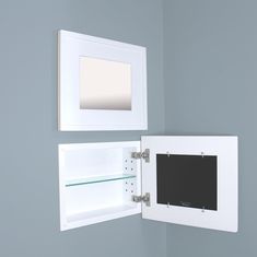 an open white wall mounted medicine cabinet next to a small mirror on the wall above it