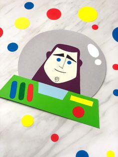 a paper cut out of a man in a space ship with polka dots on the table