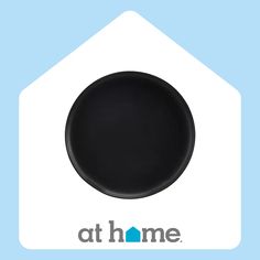 a black plate sitting on top of a blue and white house shaped sign that says at home