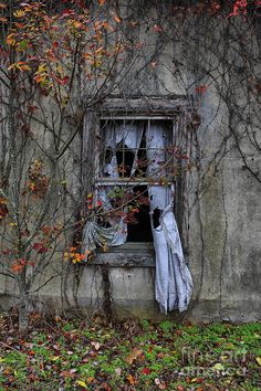 an old window with clothes hanging out of it