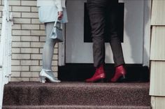 two people standing on steps with their feet in the air and one person wearing red boots