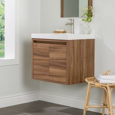 a bathroom with a sink, mirror and stool next to the wall in front of it