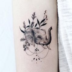 an elephant and bird tattoo on the left inner side of the arm, which is decorated with leaves