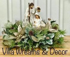 a nativity scene with figurines and greenery