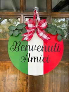 a red, white and green door hanger with the words benewauti amici on it