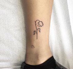 a woman's foot with a flower tattoo on her left ankle and the word love written in black ink