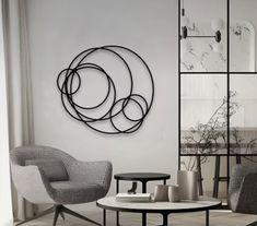 a living room filled with furniture and a circular metal wall art hanging on the wall