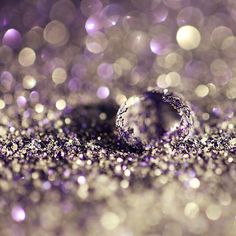 a purple and silver glitter background with a shiny ball metal print