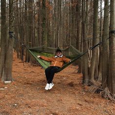 a man sitting in a hammock between two trees