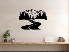 a wall mounted clock with a road and mountains in the background on a white wall