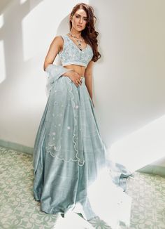 Luxurious Raw Silk Kali Lehenga in a sea blue colour teamed with a handcrafted blouse which features hand embroidered flowers and butterflies in pearls and silk thread work in sea blue, pastel pink and sage green hues. The blouse is a a product of 60 hours with every flower and butterfly exquisitely detailed. Completed with a signature organza scalloped dupatta Can be customised in any colour Composition: Lehenga and Blouse - Raw Silk Dupatta - Organza All products can be customised for sleeves, Kali Lehenga, Scalloped Dupatta, Lehenga And Blouse, Colour Composition, Sea Blue Color, Long Frock Designs, Raw Silk Lehenga, Hand Embroidered Flowers, Gold Blouse