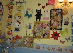 a wall covered in lots of stuffed animals and other stuff animal items next to a lamp