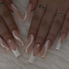 two hands with white and silver nail designs on them