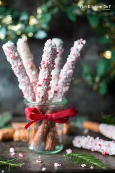 a glass jar filled with candy canes on top of a table