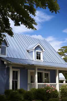 a blue house with white trim and a metal roof