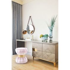 a room with a dresser, mirror and plant on it's sideboard in front of a window