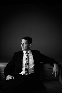 a man in a suit and tie sitting on a couch