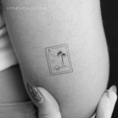 a small stamp on the side of a woman's stomach that has a palm tree in it