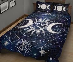 a bed covered in a blue comforter with white stars and moon phases on it