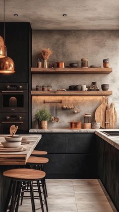 a kitchen with black cabinets and wooden stools in front of a counter top that has pots on it