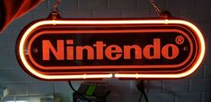 a neon sign hanging from the side of a brick wall that says nintendo on it