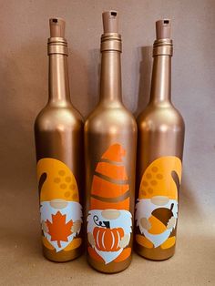 three bottles with designs on them sitting next to each other