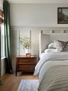 a bed with white sheets and pillows in a bedroom