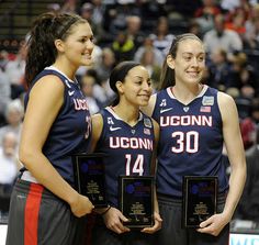 three women basketball players standing next to each other with plaques in front of their chests