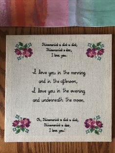 a cross stitch poem on a wooden table