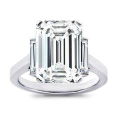 an emerald - cut diamond ring with three baguets on the shoulders and sides