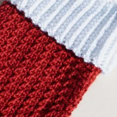 two crocheted red and white blankets sitting next to each other