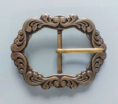 a gold colored belt buckle with an ornate design