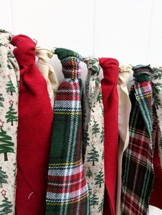 several different colored ties hanging on a white wall with christmas trees and snowflakes