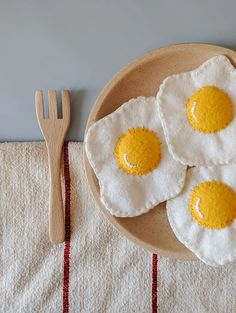 three fried eggs are sitting on a plate next to a fork and knife, along with a napkin