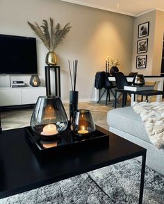 a living room filled with furniture and a flat screen tv on top of a wooden table