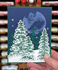 someone holding up a christmas card with trees