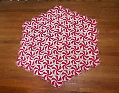 a red and white rug sitting on top of a wooden floor next to a cat