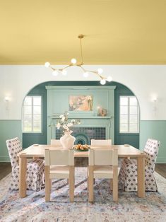 a dining room with blue walls and white chairs