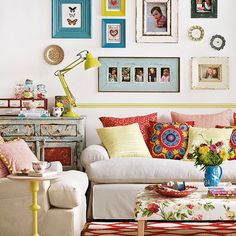 a living room filled with lots of furniture and pictures on the wall above it's coffee table