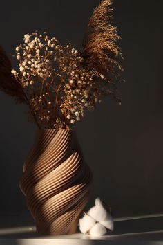 a vase filled with dried flowers on top of a table