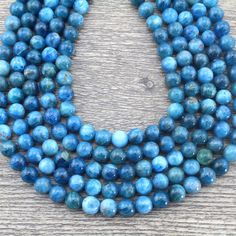 three strands of blue glass beads on a wooden surface