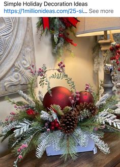 a christmas centerpiece with red balls and greenery