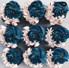 cupcakes with blue frosting and white flowers arranged in the shape of a flower