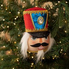 a nutcracker ornament hanging from a christmas tree