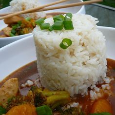 rice, broccoli and carrots are in a bowl with chopsticks