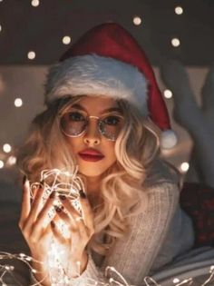 a woman laying on top of a bed covered in christmas lights