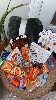 a basket filled with candy and snacks sitting on top of a chair