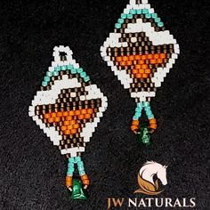 two beaded earrings with orange and blue beads on black carpeted area next to logo for jw naturals