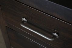 a close up of a wooden drawer with metal handles