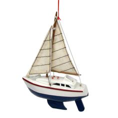 a sailboat ornament hanging on a white wall